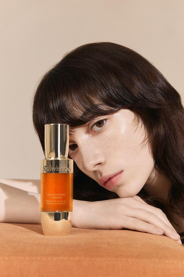 Model lying down staring at Concentrated Ginseng Renewing Serum 