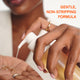 Enlarge image of Person applying a skincare product to their hand with text &amp;#39;Gentle, Non-Stripping Formula&amp;#39; in the corner.