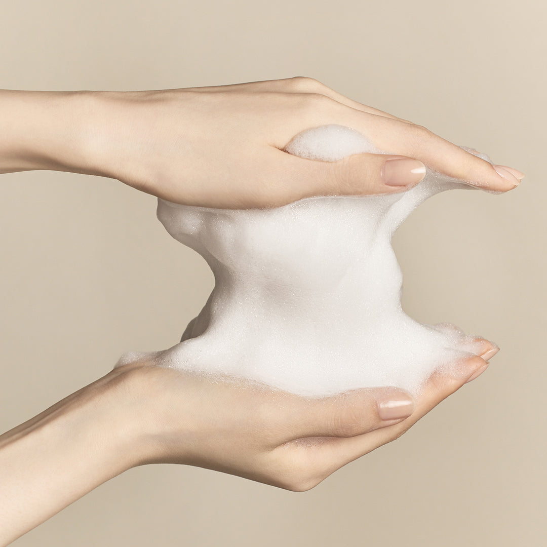 Hand model holding foam from Signature Ginseng Facial Soap 