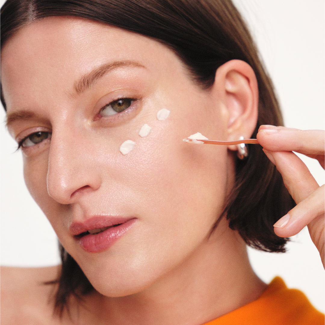 Model applying Concentrated Ginseng Rejuvenating Eye Cream to the eye area with spatula