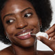 Enlarge image of Woman applying lip balm to her lips with a white background
