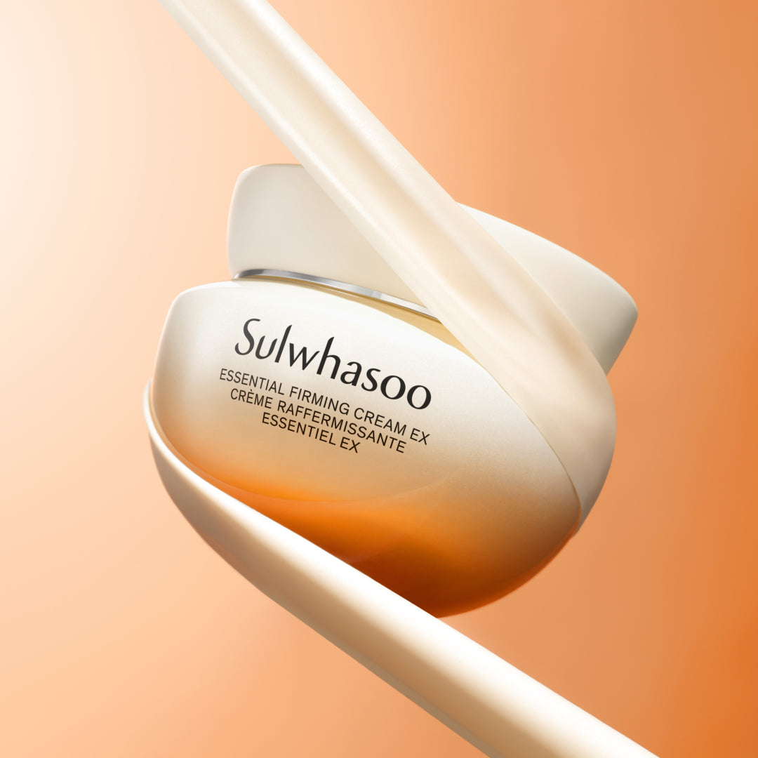 Sulwhasoo cream jar with applicator on a peach background
