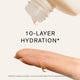 Enlarge image of Hand applying a skincare product with &amp;#39;10-Layer Hydration&amp;#39; text on a light background