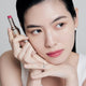 Enlarge image of Fair skin beauty model holding and wearing product in shade NO.370 Peony