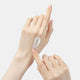 Enlarge image of Hand applying a small amount of cream on a light gray background