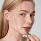 Enlarge image of Light skin beauty model holding and wearing product in shade NO.520 Amber