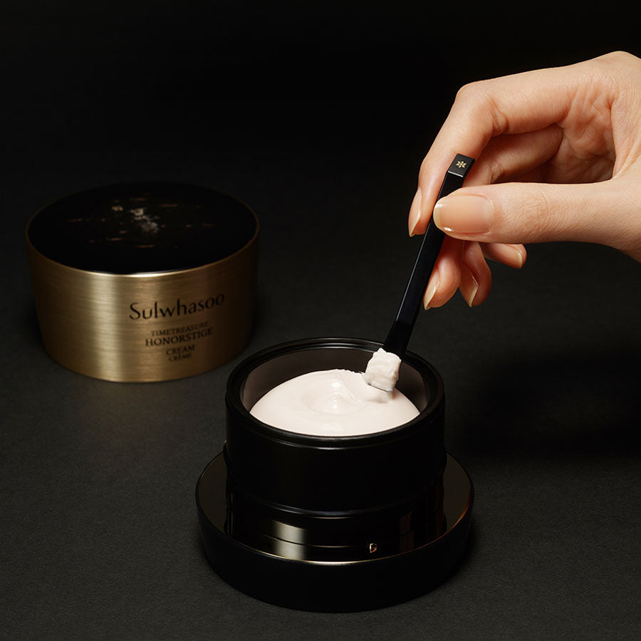 Hand model scooping Timetreasure Honorstige Cream from jar with spatula